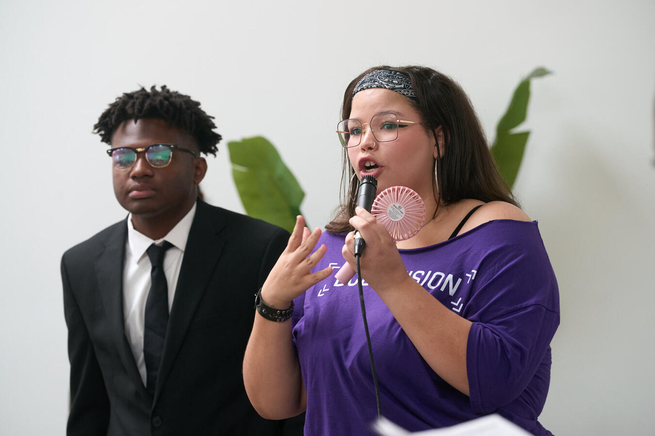 Youth Council Member Speaking A Bold Vision Youth Council member speaks into a microphone beside another member.