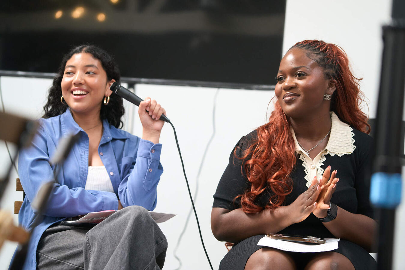 Two panelists speak together on stage during a session at the October Youth Summit.
