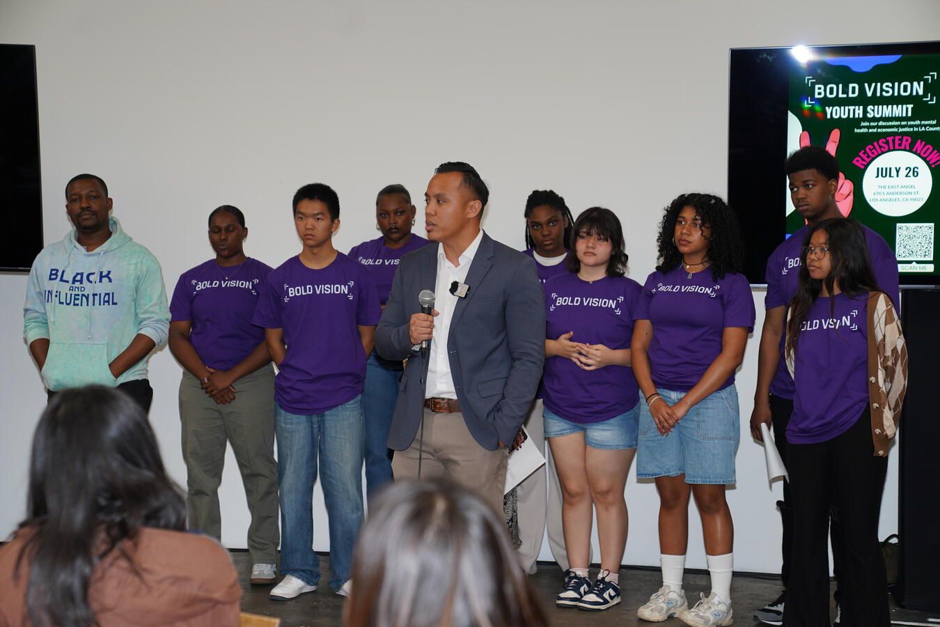 A speaker addresses attendees on stage at the Bold Vision Youth Summit.