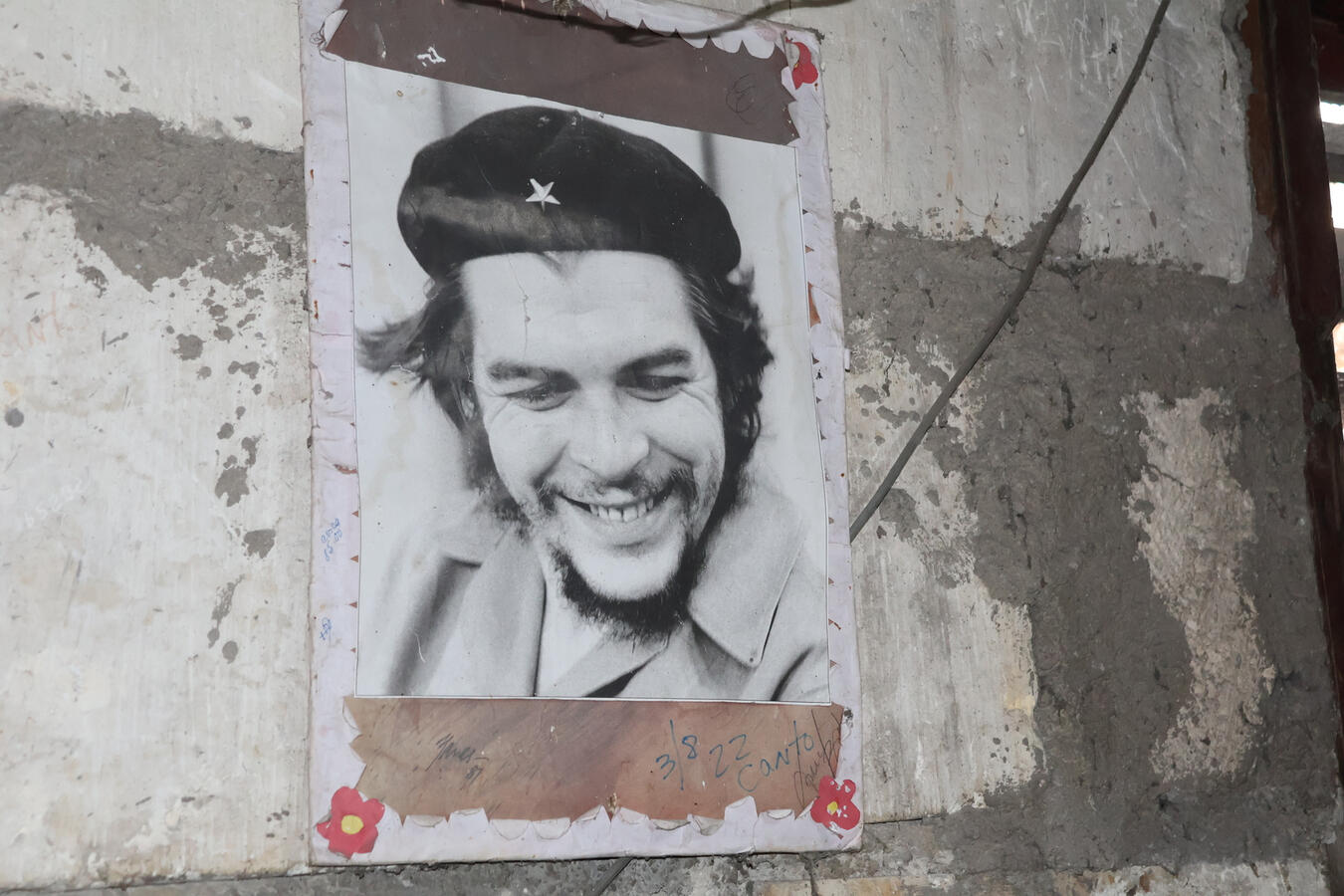A framed photograph of Che Guevara is displayed on a wall in Havana.