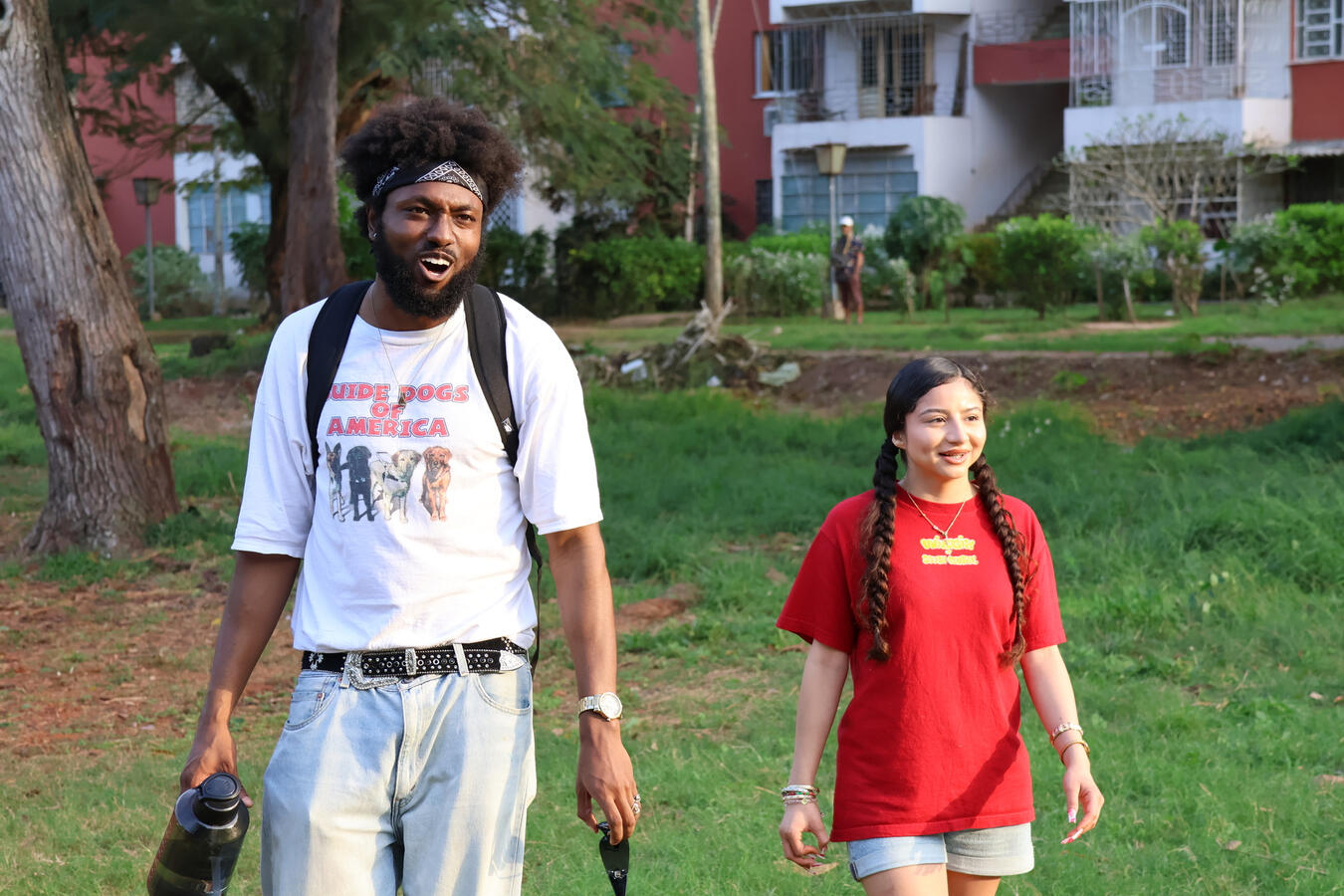 Two delegation members stand together on a grassy area in Havana.