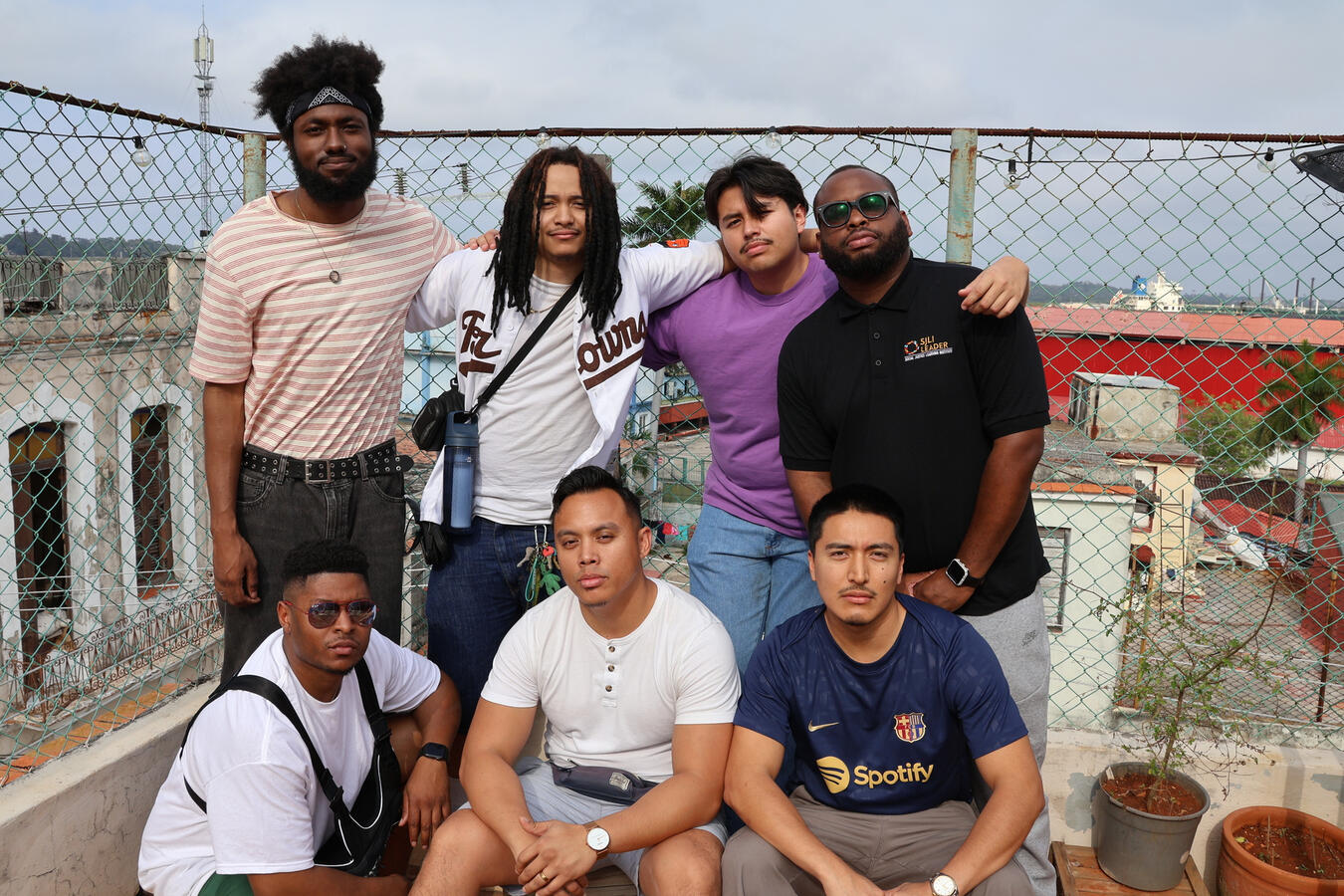 Fellows Gathered at a Rooftop Fence A small group of delegation members poses together against a chain-link fence.