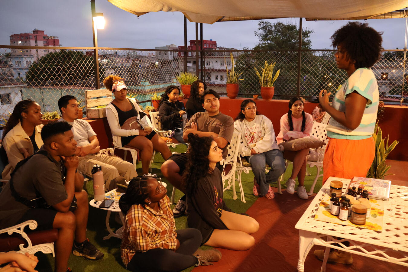 A host speaks to the delegation during an evening gathering on a rooftop in Havana.