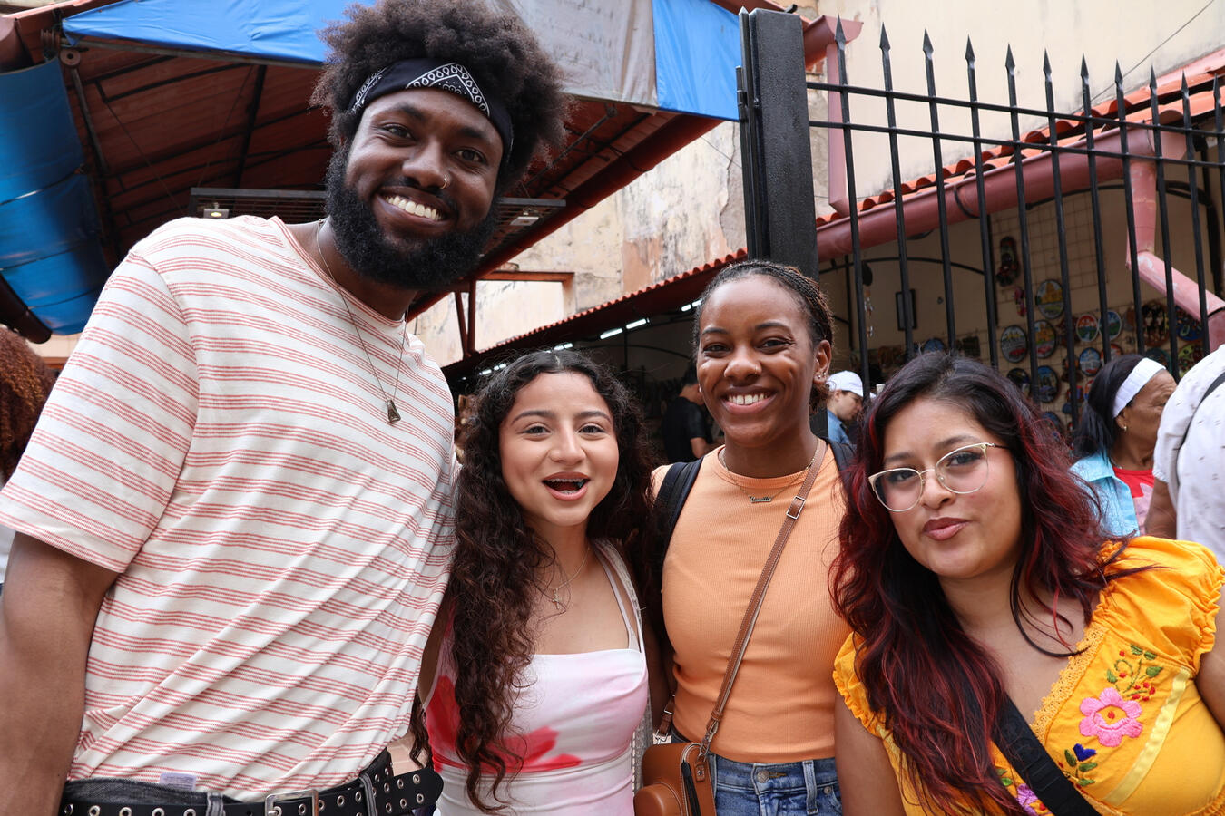 Three delegation members pose together under a market awning in Havana.