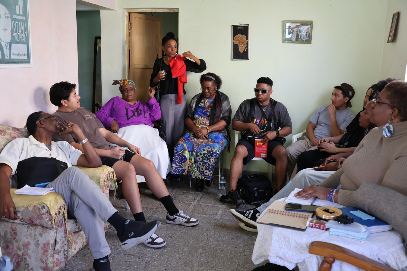 Fellows sit in conversation with local hosts inside a home in Havana.