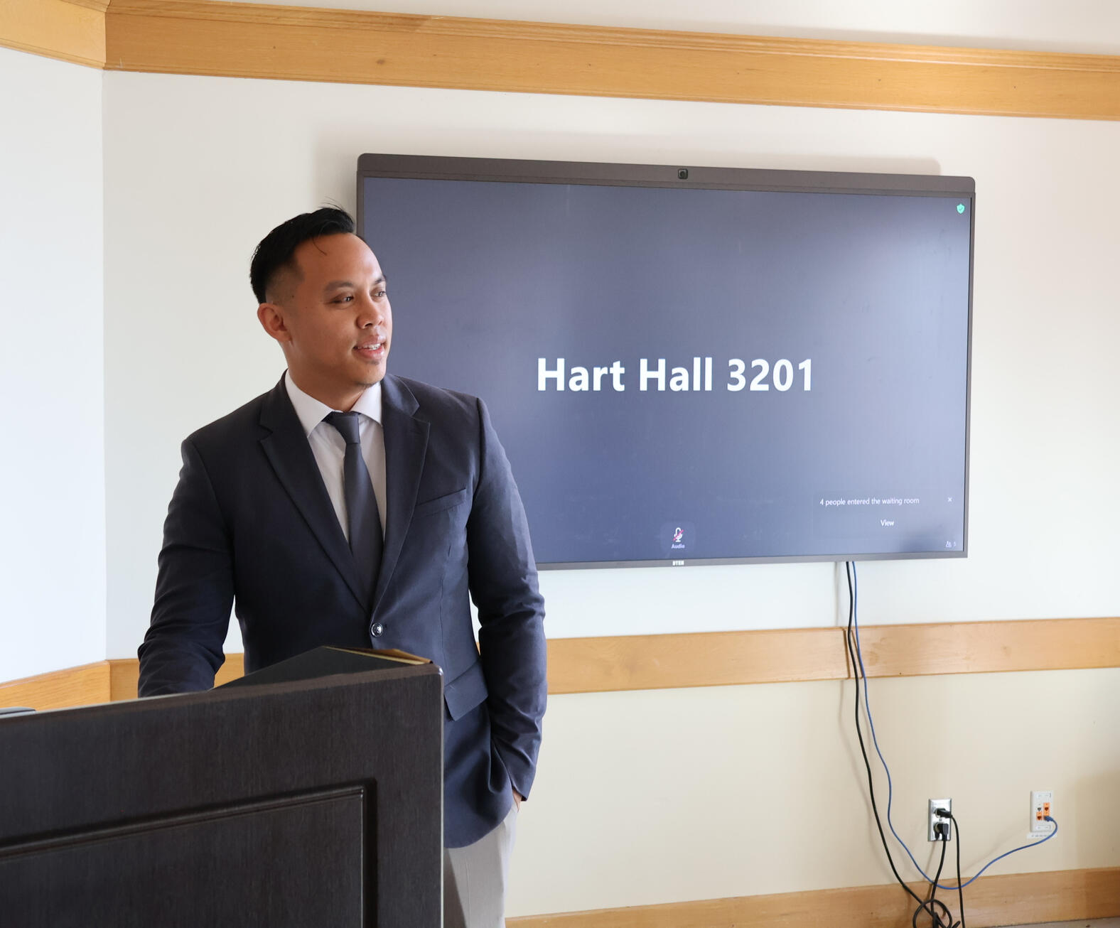 Gabriel Regalado Speaking at UC Davis Gabriel Regalado stands at a podium in Hart Hall, UC Davis, presenting to an audience.